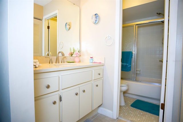 full bath with combined bath / shower with glass door, tile patterned floors, vanity, and toilet