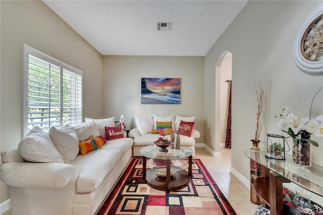 living room with a textured ceiling and light tile patterned flooring