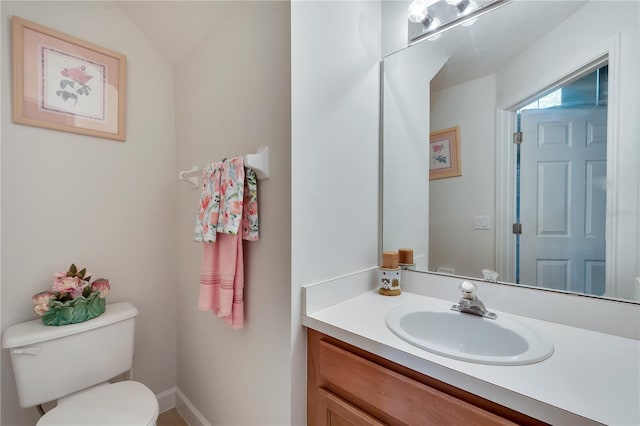 bathroom with vaulted ceiling, vanity, and toilet