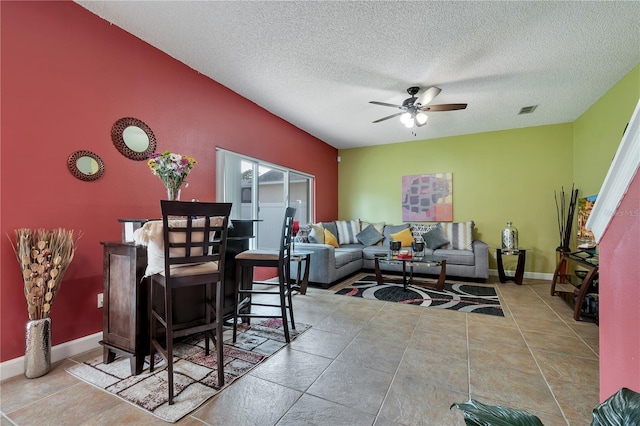 living room with ceiling fan and a textured ceiling