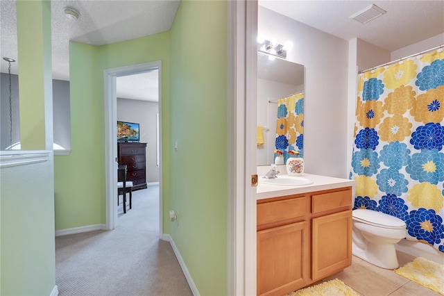 bathroom featuring a textured ceiling, vanity, and toilet