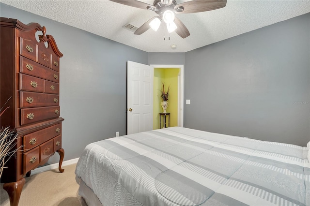 bedroom featuring a textured ceiling, ceiling fan, and light colored carpet