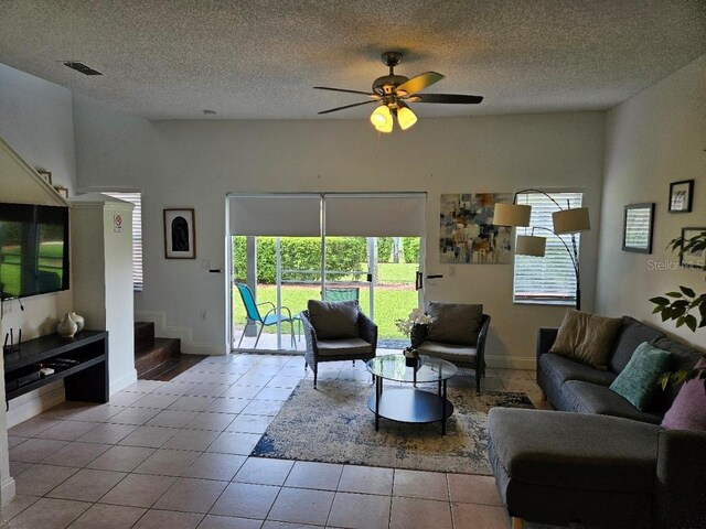 tiled living room featuring ceiling fan and a textured ceiling