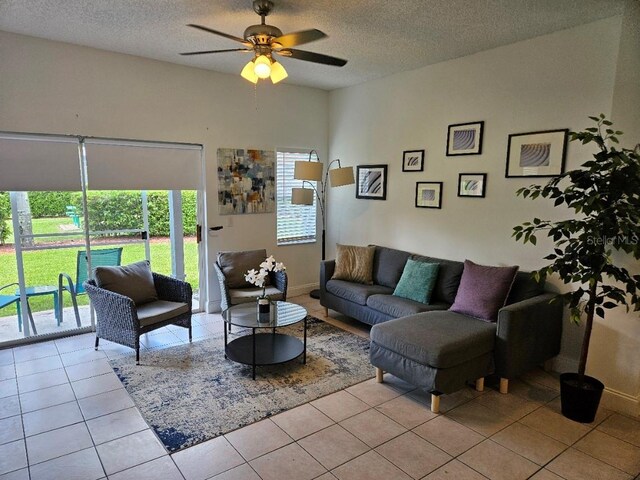 tiled living room with ceiling fan and a textured ceiling