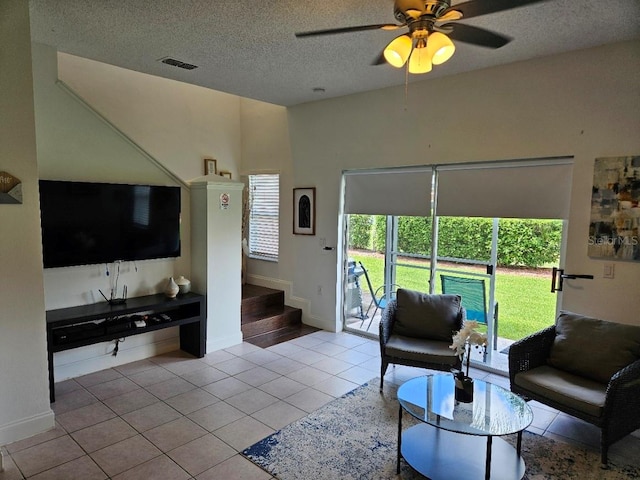 tiled living room featuring ceiling fan, plenty of natural light, and a textured ceiling