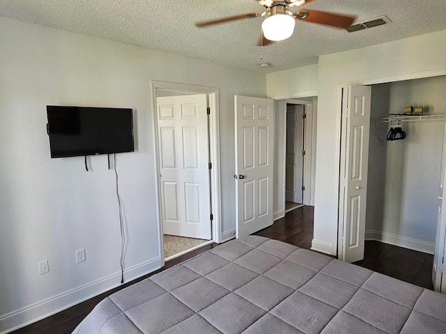 unfurnished bedroom with ceiling fan, a textured ceiling, a closet, and hardwood / wood-style flooring