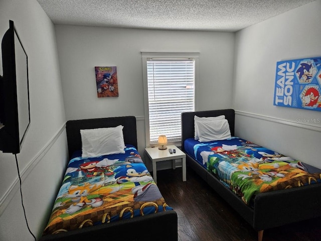 bedroom featuring a textured ceiling and dark wood-type flooring