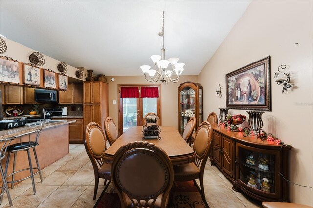 dining room with light tile patterned floors, vaulted ceiling, sink, and a chandelier