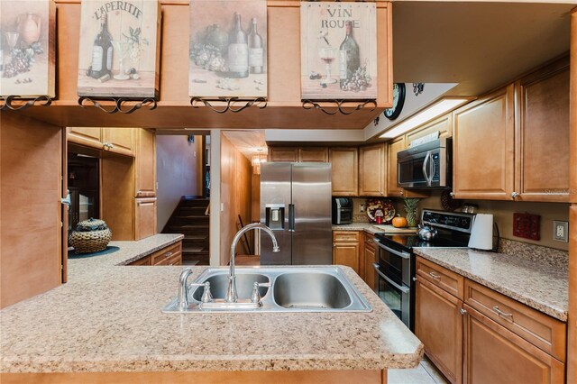 kitchen with stainless steel appliances, a center island with sink, and sink