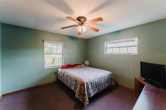 carpeted bedroom featuring ceiling fan, a textured ceiling, and multiple windows