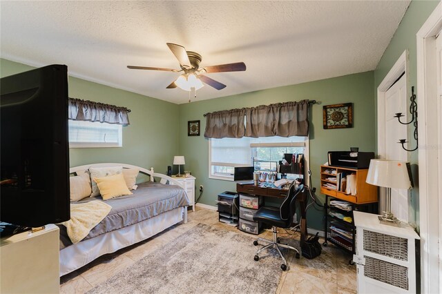 bedroom with ceiling fan and a textured ceiling