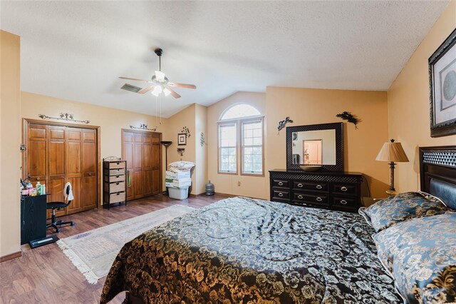 bedroom with ceiling fan, a textured ceiling, vaulted ceiling, and wood-type flooring