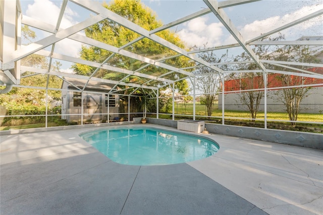 view of swimming pool featuring glass enclosure and a patio area