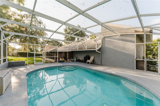 view of swimming pool featuring a patio and a lanai