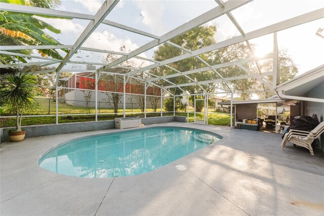 view of swimming pool with glass enclosure and a patio