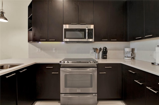 kitchen with dark brown cabinetry, pendant lighting, appliances with stainless steel finishes, and sink