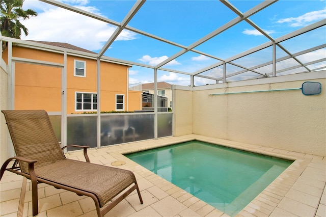 view of swimming pool with glass enclosure and a patio area