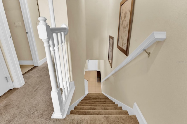 staircase featuring carpet flooring