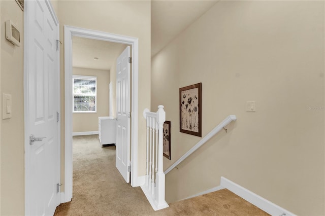 corridor featuring light colored carpet