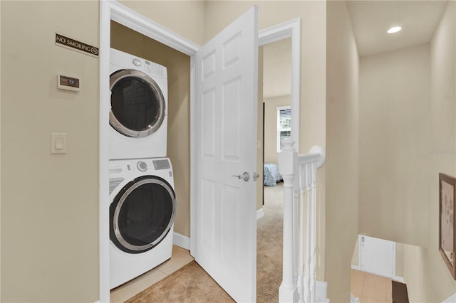 laundry area with light carpet and stacked washer / drying machine