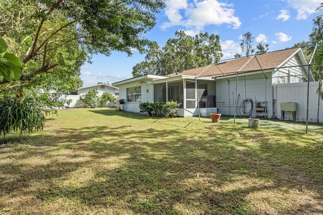 back of house featuring a sunroom and a yard