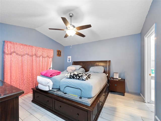 bedroom featuring light wood-type flooring, vaulted ceiling, and ceiling fan