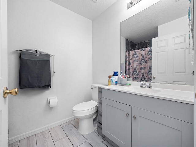 bathroom featuring curtained shower, a textured ceiling, vanity, and toilet