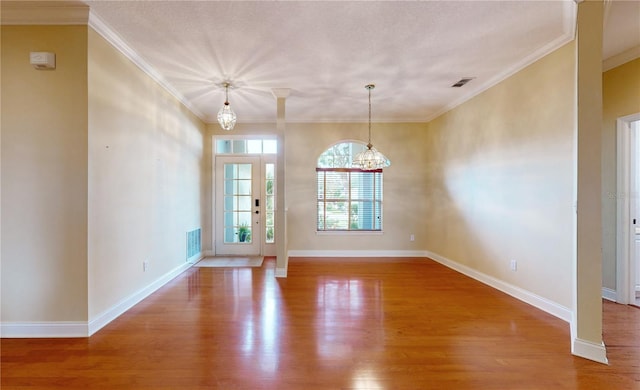 unfurnished dining area featuring a notable chandelier, hardwood / wood-style flooring, and crown molding