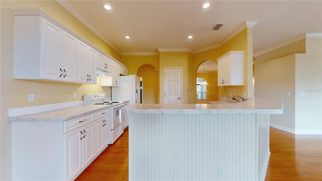 kitchen featuring light hardwood / wood-style flooring, kitchen peninsula, crown molding, white cabinetry, and white appliances