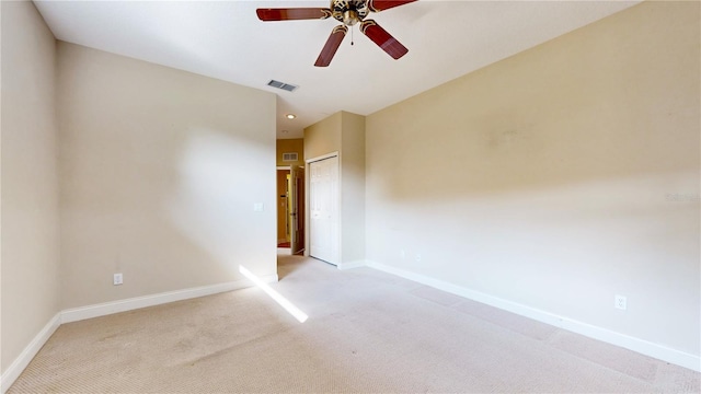 empty room featuring ceiling fan and light colored carpet