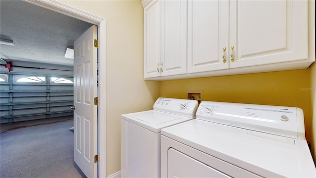 washroom with washing machine and clothes dryer, light carpet, a textured ceiling, and cabinets