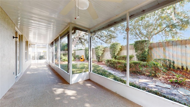 unfurnished sunroom with ceiling fan