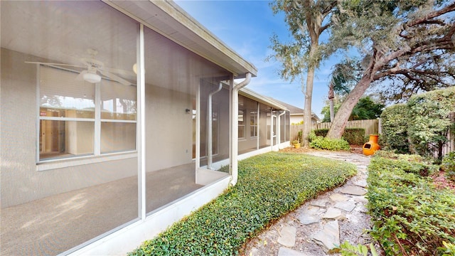 view of yard featuring a sunroom and ceiling fan