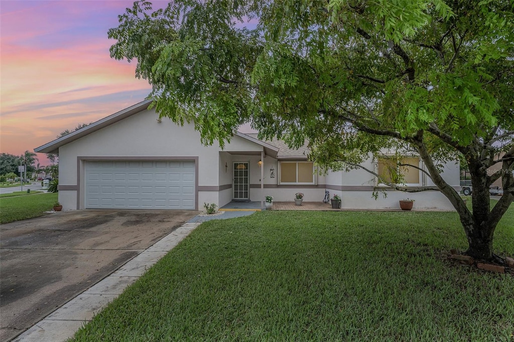 ranch-style home featuring a yard and a garage