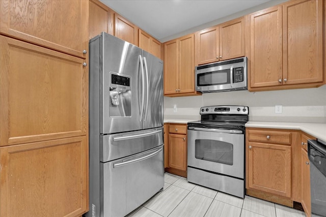 kitchen featuring light tile patterned floors, appliances with stainless steel finishes, and light countertops