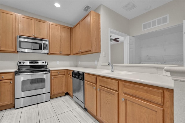 kitchen featuring sink, appliances with stainless steel finishes, ceiling fan, and light tile patterned floors