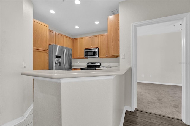 kitchen with kitchen peninsula, hardwood / wood-style flooring, appliances with stainless steel finishes, and light brown cabinets