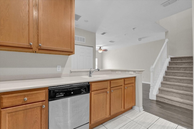 kitchen with kitchen peninsula, ceiling fan, stainless steel dishwasher, light hardwood / wood-style flooring, and sink