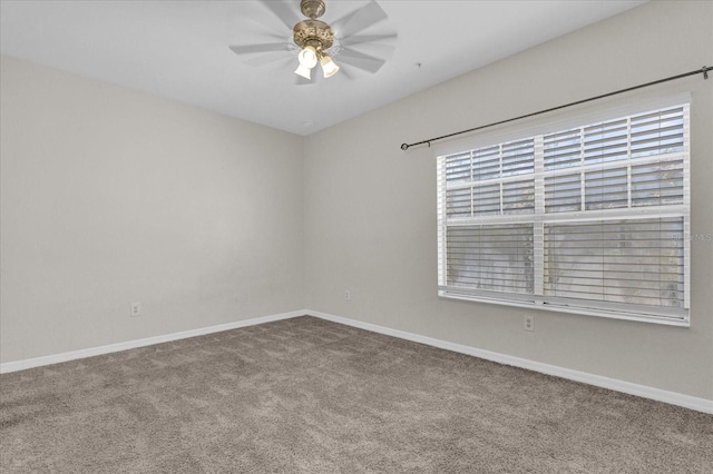 empty room featuring ceiling fan, carpet, and baseboards
