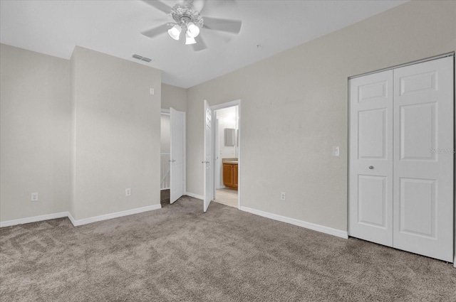 unfurnished bedroom with ensuite bath, light carpet, a closet, and ceiling fan