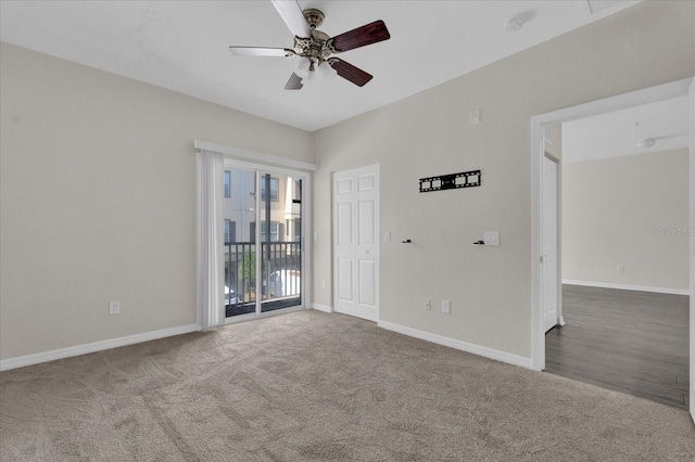 carpeted spare room with ceiling fan and baseboards