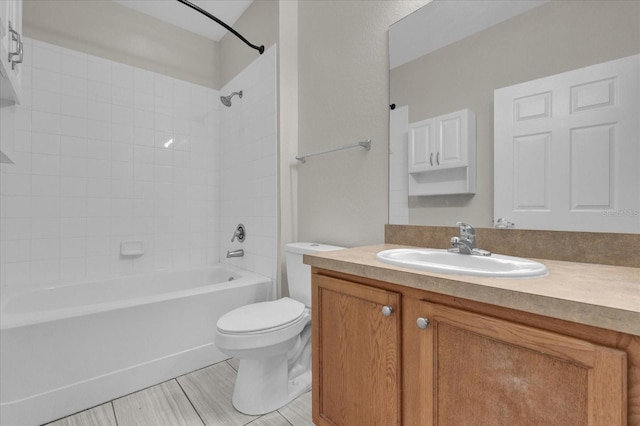 full bathroom with vanity, toilet, wood-type flooring, and tiled shower / bath