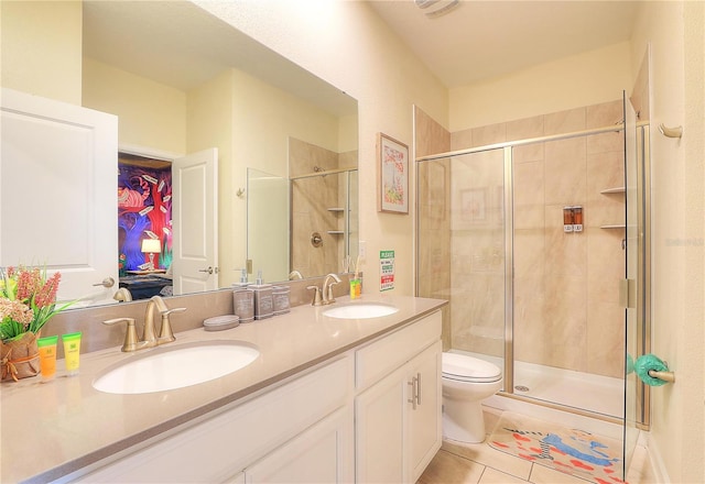 bathroom with tile patterned floors, vanity, toilet, and a shower with shower door