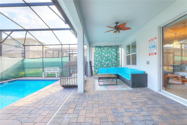 view of pool with ceiling fan, a lanai, an outdoor living space, and a patio