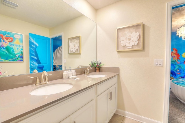 bathroom with tile patterned flooring, vanity, and a textured ceiling