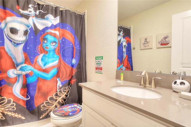 bathroom featuring a shower with curtain, vanity, and toilet