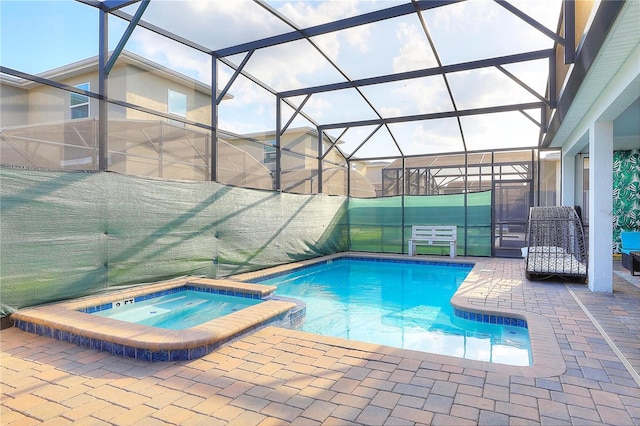 view of swimming pool featuring glass enclosure, an in ground hot tub, and a patio