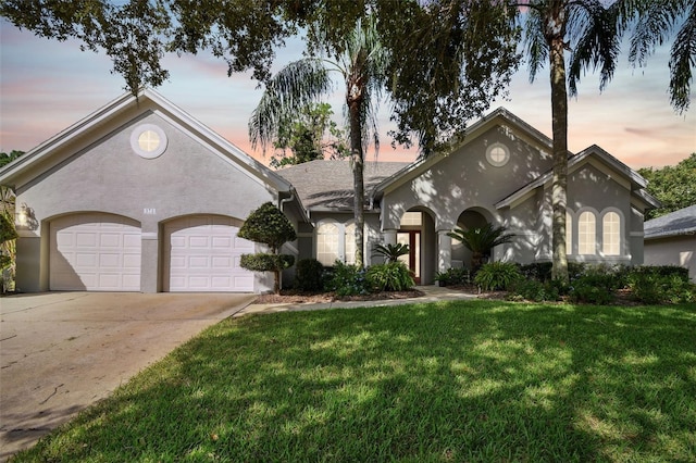 view of front of home with a yard and a garage