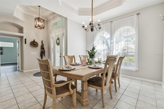 dining area featuring crown molding, a tray ceiling, light tile patterned floors, and a notable chandelier