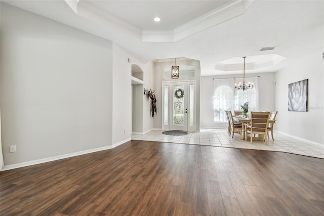 entryway featuring a raised ceiling, a chandelier, and hardwood / wood-style floors